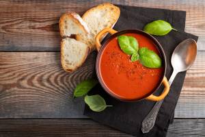 Tomato soup in a bowl with crusty bread.